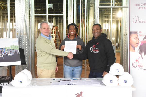 Lease agreement signed! L to R: John Mangham, property owner; Aisha Moody, co-founder & director of choirs; Dantes Rameau, co-founder & executive director